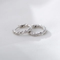 S925 Sterling Silber gedrehte Creolen mit Zirkonia-Steinen auf weißem Stoffhintergrund - 925er Silber / Silber