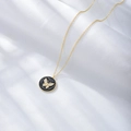 Detail of a gold butterfly pendant with sparkling diamonds and black enamel texture - 925 Silver / Gold