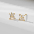 Minimalist silver four-leaf clover stud earrings with sparkling white zircons on a white podium - 925 Silver / Gold