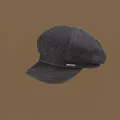 Detail of a black denim newsboy cap featuring white contrast stitching and a metal emblem - 56-58cm Adjustable / Black