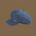 Detailed view of blue denim octagonal hat with metal logo tag and yellow topstitching - 56-58cm Adjustable / Dark Blue