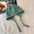 Cozy turquoise knit earflap hat with tie strings on a decorative rustic background - Mint Green