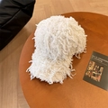 Gorra de béisbol blanca y peluda con textura de flecos sobre un fondo de madera - Blanco