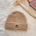 Distressed khaki knit beanie with fox embroidery and NANBADE logo on a textured surface - Khaki