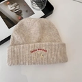Oatmeal knit beanie with red 'lucky pipiegg' puppy embroidery in a lifestyle setting - 56-62cm / Beige Khaki