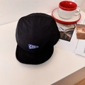 Black short-brimmed camp cap with blue triangle COOL patch in a casual lifestyle setting - 56-58cm / Black