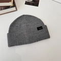 Grey ribbed knit beanie hat for winter with a black square woven label on white background - 56-58cm (Elastic) / Knitted Beanie / Light Gray