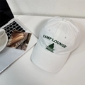 White cotton baseball cap featuring green Camp Lounge embroidery on a white desk - 56-58cm Adjustable / White