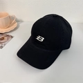 Black cotton baseball cap with white embroidered B logo shown in a casual lifestyle setting - 56-58cm Adjustable / Black