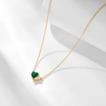 Close-up of heart-shaped emerald zircon pendant on gold chain with soft shadow - 925 Silver / Gold