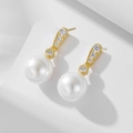 Dettaglio macro di orecchini di perle in argento S925 dorato con zirconi su base bianca - Argento 925 / Oro