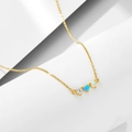 Dettaglio di una collana dorata con tre pietre circolari di opale e zircone su pietra bianca - Argento 925 / Oro
