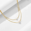 Dettaglio di una collana dorata a due strati con due perle bianche su sfondo bianco puro - Argento 925 / Oro