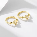 Macro shot of gold square zircon earrings with geometric rivets on white background - 925 Silver / Gold