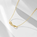 Macro shot of gold infinity pendant with pave zircons on a delicate O-link chain - 925 Silver / Gold