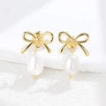 Elegant S925 silver bow stud earrings with natural freshwater pearls on stone surface - 925 Silver / Gold