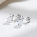 S925 silver stud earrings featuring natural moonstone and cubic zirconia on a stone surface - 925 Silver / White