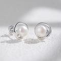 Minimalist round natural pearl stud earrings with silver borders on a textured stone base - 925 Silver / White