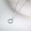 S925 Sterling zilveren ketting met drie vervlochten ringen en diamanten op een keramiek bord - 925 zilver / Zilver
