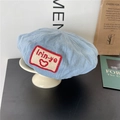 Light blue denim beret with red patch detail on a stylish white ceramic display stand - Kids 52cm / Light Blue