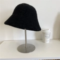 Minimalist black faux shearling bucket hat with textured finish on a display stand - 56-59cm / Black