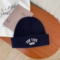 Navy blue knit beanie with white New York embroidery on a rustic wooden desk surface - 56-65cm (Elastic) / Navy Blue