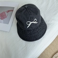 Black denim bucket hat with white bow embroidery on a textured fabric background - 56-58cm Adjustable / Black