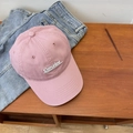Pink cotton baseball cap with white Consice embroidery displayed on a wooden surface - Pink