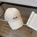 Beige distressed baseball cap with Naivety 1768 embroidery in a wire basket - Beige