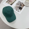 Distressed dark green cotton baseball cap with vintage ripped details on a white table - 56-59cm (Adjustable) / Green