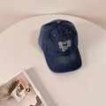 Berretto da baseball in denim blu scuro con toppa a fiocco bianca e nera su tavolo - 56-58cm Regolabile / Blu scuro