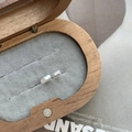 Macro shot of minimalist silver cylinder stud earrings placed in a wooden jewelry box - Cylindrical Style / 925 Silver