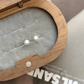 Macro detail of geometric S925 sterling silver stud earrings in a wooden jewelry box - Polyhedron Ball Style / 925 Silver