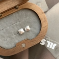 Detailed view of silver pyramid stud earrings on a grey velvet display pad - Pyramid Style / 925 Silver