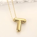 Close-up of golden 3D puffer letter T pendant on a necklace with mirror finish - Gold Letter T