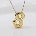 Detaillierte Makroaufnahme eines goldenen Buchstabe S Anhängers mit glatter Metalloberfläche - Gold Buchstabe S / Anhänger + Halskette 45+5cm