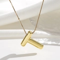 Makro-Detail des goldenen 3D-Buchstaben-T-Anhängers mit einer feinen Perlenhalskette - Gold Buchstabe T / Anhänger + Halskette 45+5cm