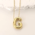 Polished golden puffy balloon letter G pendant necklace on minimalist white stone - Gold Letter G