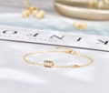 Vista detallada de la pulsera con dije cilíndrico dorado y piedras de circón brillante - Plata 925 / Champán