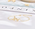 Vista macro de la pulsera de mariposa dorada con circonitas blancas en cadena delicada - Plata 925 / Champán