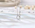 Macro view of geometric interlocking s925 silver pendant with sparkling pave zirconia stones - 925 Silver / White Gold
