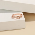 Vista macro di un anello a nodo d'amore in argento S925 oro rosa con zirconi - Regolabile / Oro rosa