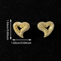 Détail macro de boucles d'oreilles cœur dorées avec oxydes de zirconium et mesures - Doré