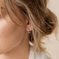 S925 sterling silver hoop earrings featuring light blue crystal flower clusters on model - 925 Silver / White Gold