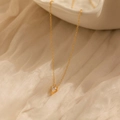 Detailaufnahme eines minimalistischen quadratischen Goldanhängers auf beigem Stoff - 925 Silber (40+5cm) / Gold
