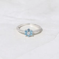 Bague fleur en argent 925 avec zircons bleus et pierre centrale sur fond de marbre - Taille US 6 / Or Blanc