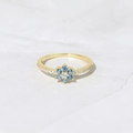 Bague fleur en or avec zircon bleu et diamants pavés sur une surface en marbre blanc - Taille US 6 / Or