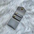 Detail view of grey PU jewelry pouch with gold snaps and internal earring organizers - Gray