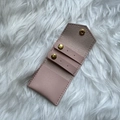 Detail view of pink suede jewelry pouch with stud earring straps and gold snap button - Pink