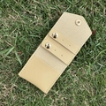 Close-up of portable PU jewelry pouch with golden snaps on a natural grass background - Apricot